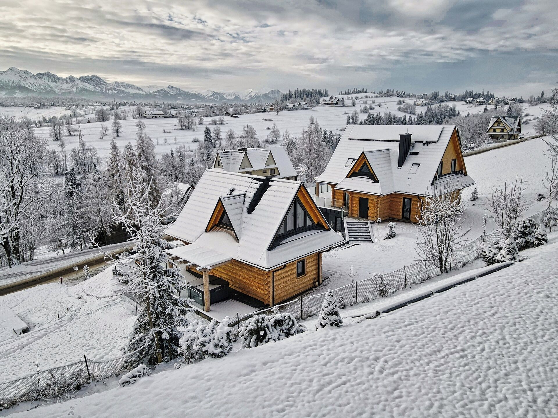 Eine verschneite Landschaft mit einer Holzhütte, einem geneigten Dach und einer kleinen Veranda.