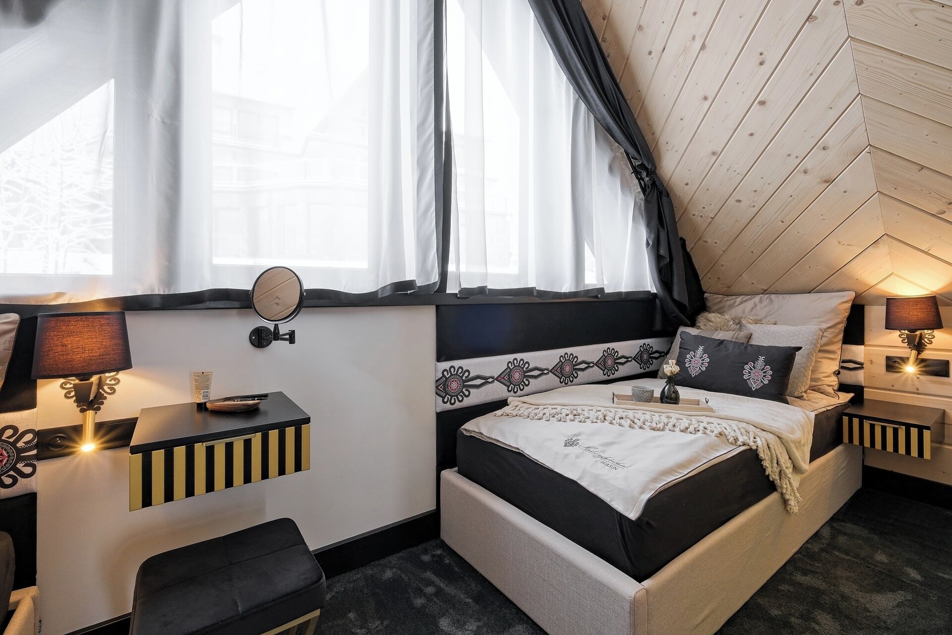 Une chambre confortable avec un lit, des tables de chevet, un bureau et une fenêtre avec des rideaux.