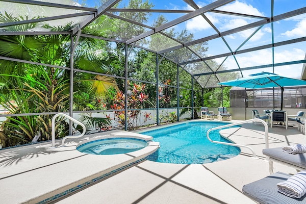 Surrounded by tropical landscaping, the screened-in pool and spa at Seasons offers a serene escape just minutes from Disney.