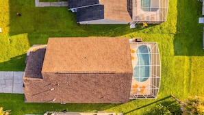 A residential property with a brick house, a swimming pool, and a well-maintained lawn. - Disney Area, Pool, Game Room, Perfect for Families (Kissimmee)