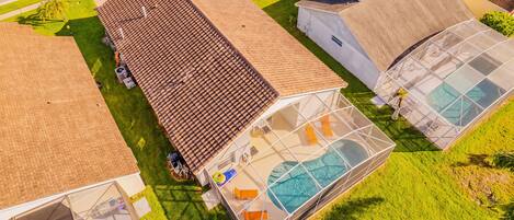 A large house with a swimming pool, a greenhouse, and a garage.