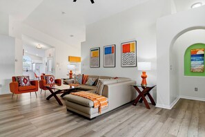 A modern living room with a sofa, chairs, and a dining area. - Perfect Family Disney Escape: Pool & Games (Kissimmee)