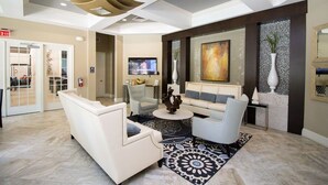 A modern lobby with a white sofa, armchairs, a coffee table, and a large painting on the wall. - Luxury Resort Villa with Pool, Spa – Perfect for Families! (Davenport)