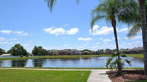 Un quartier résidentiel avec un lac, des maisons et un sentier.