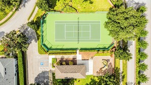 An aerial view of a tennis court surrounded by trees and a parking area. - Spacious 5BR West Haven Villa Near Disney | Private Pool, Spa & Game Room (Davenport)