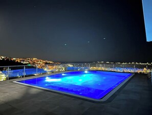 A rooftop pool with a view of a cityscape at night. - Elegant apartment overlooking the sea with infinity pool, beach 5 minutes away. (Albufeira)