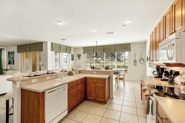 A modern kitchen with a central island, wooden cabinets, and a dishwasher.