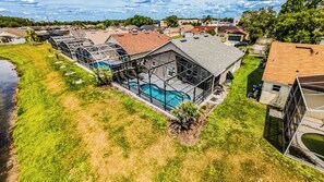 Un immobile residenziale con piscina, area esterna coperta e vista sulle case vicine.