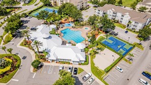An aerial view of a residential area with a large swimming pool, tennis courts, and a parking lot. - Windsor Palms Villa, Pool, Spa, Game Room, Near Disney (Kissimmee)