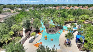 A resort with a central swimming pool, surrounded by palm trees and lounge chairs. - Stunning Lake Views | Pool, Spa & Game Room (Davenport)