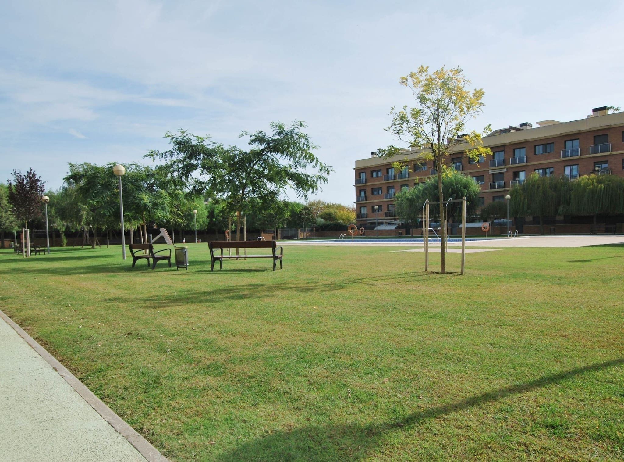 A park with benches, trees, and a playground.