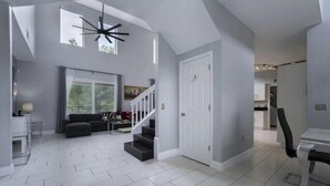 A spacious living area with a staircase, a dining table, and a sofa.