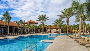 A swimming pool with multiple lanes, surrounded by palm trees and lounge chairs. - Modern 5BR Oasis w/ Pool, Spa & Resort Perks (Davenport)
