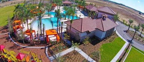 A resort with a swimming pool, palm trees, and a playground.