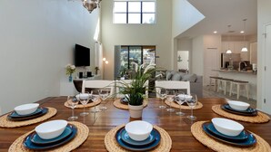 A spacious dining area with a high ceiling, a large window, and a view of the outdoors. - Modern 5BR Oasis w/ Pool, Spa & Resort Perks (Davenport)