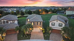 A residential area with houses featuring sloped roofs and a well-maintained lawn. - 5BR Near Disney with Pool, Spa, Theater & Sensory Room (Davenport)