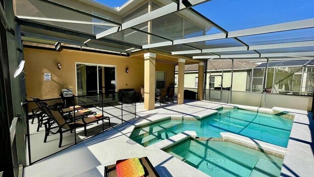 A rooftop pool area with glass railings, lounge chairs, and a clear view of the sky. - Spacious 4BR Villa with Private Pool Near Disney (Davenport)