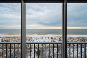 A view from a balcony overlooking a beach with snow on the ground and a cloudy sky. - Wonderful Ocean Views from this 2 Bedroom Oceanfront With a Pool (Ocean City)