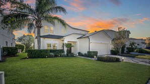 A residential house with a well-maintained lawn, a garage, and a driveway. - Disney Villa Free BBQ, Pool & Game Room (Davenport)