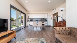A modern living room with a TV, sofa, and dining area.