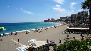 Una playa con parque acuático, sombrillas y una torre de salvavidas.