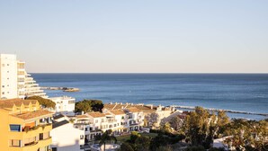 Un hotel costero con varias edificaciones, vista al mar y un rompeolas rocoso.