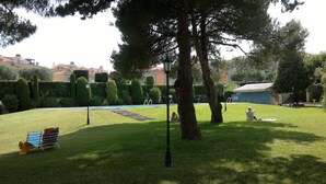 A well-maintained grassy area with a pool, trees, and a lamp post. - FULLY EQUIPPED APARTMENT IN ONE OF THE BEST BEACHES ON THE COSTA BRAVA (Sant Feliu de Guíxols)