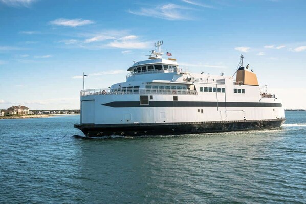 Ein großes, weißes Kreuzfahrtschiff mit mehreren Decks und einem markanten Schornstein, das auf ruhigem Wasser fährt.