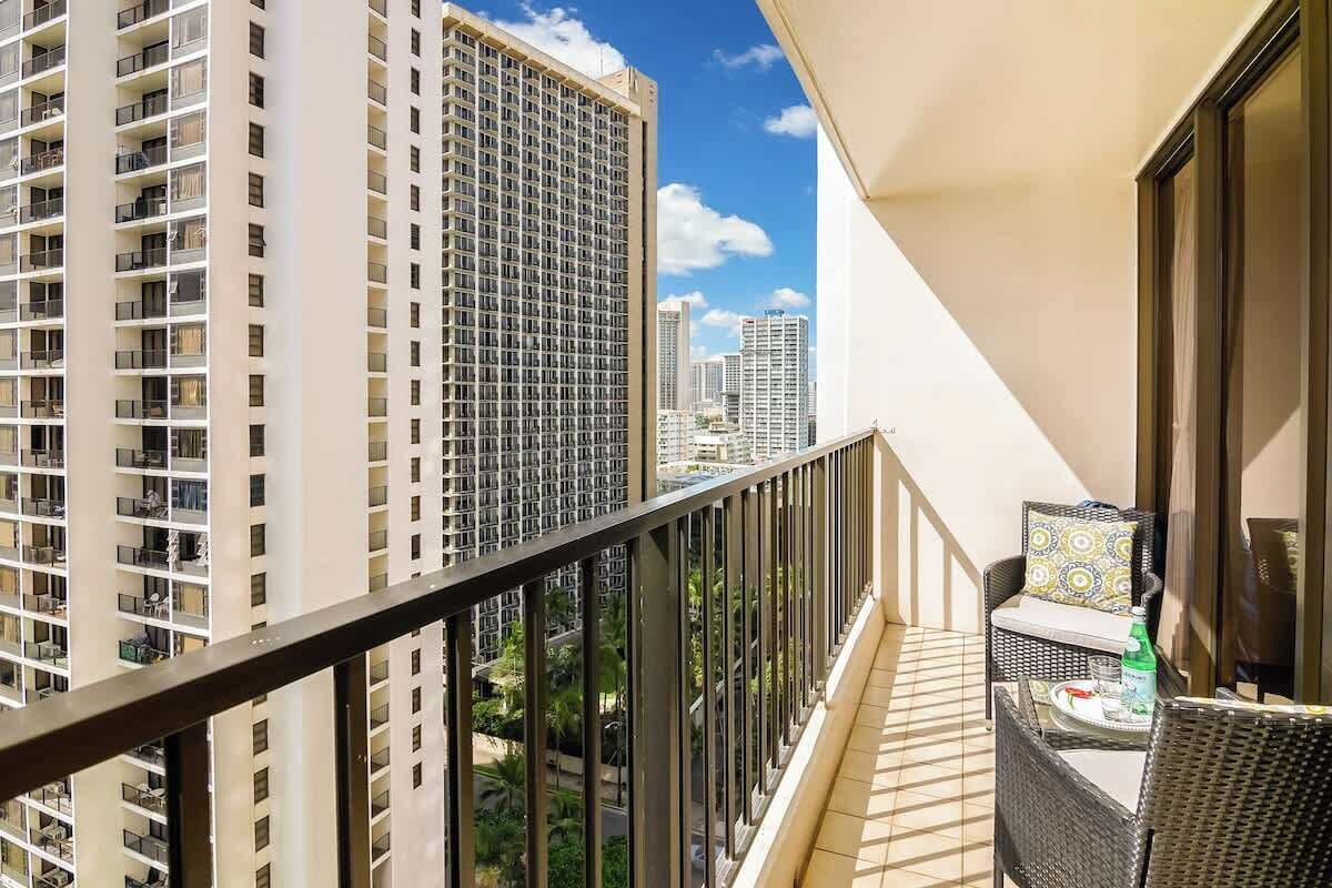 Un balcone con vista su edifici moderni, una ringhiera e mobili da esterno.