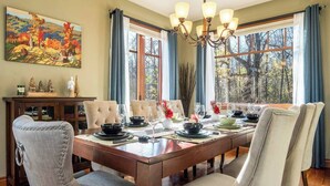 Comedor con una mesa de madera dispuesta para seis personas, rodeada de sillas tapizadas.