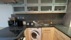 A compact kitchen with a washing machine, a sink, and a microwave. - 1br-wifi-freesnacks-freeparking-petsok-retroarcade (Newcastle-upon-Tyne)