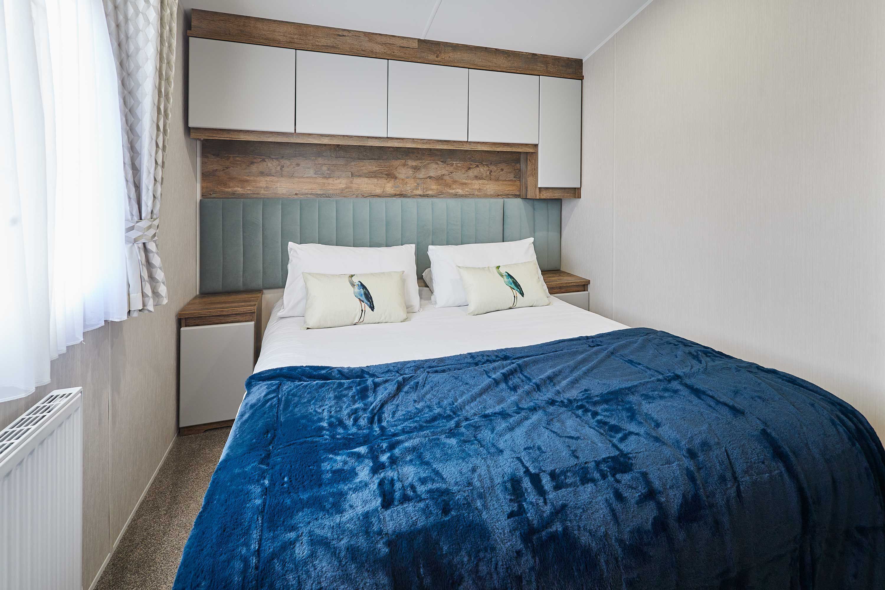 Ein Schlafzimmer mit einem Bett, einem Holz-Kopfteil, einem Nachttisch und einem Einbauschrank.