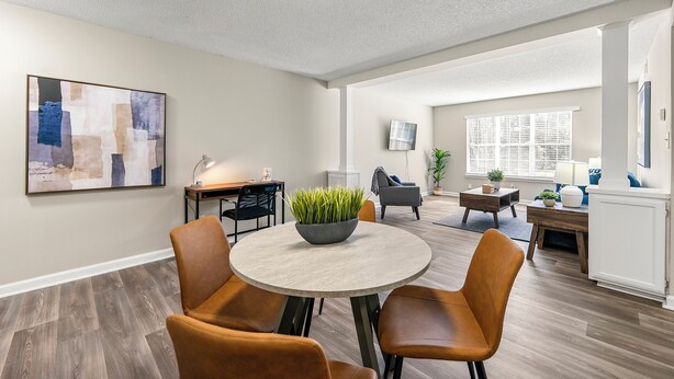 A modern living room with a round table, two brown leather chairs, a gray sofa, and a coffee table with a plant. - Upper Westside Atlanta 2BR apartment with king beds, full kitchen, fast Wi-Fi, and free parking — close to dining, shopping, and MARTA. (Atlanta)