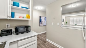 A kitchen with white cabinets, a microwave, and a toaster on the counter. - Upper Westside Atlanta 2BR apartment with king beds, full kitchen, fast Wi-Fi, and free parking — close to dining, shopping, and MARTA. (Atlanta)