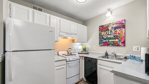 A modern kitchen with white cabinetry, a built-in stove, and a dishwasher. - Upper Westside Atlanta 2BR apartment with king beds, full kitchen, fast Wi-Fi, and free parking — close to dining, shopping, and MARTA. (Atlanta)