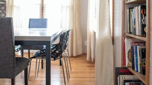 A room with a wooden floor, a dining table with chairs, a ceiling fan, and a bookshelf filled with books. - 1st flr nr Shaker, RTA rail, Cle Clinic & Univ. Ho (Akron)