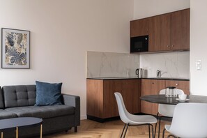 A modern kitchen with wooden cabinets, a microwave, and a marble backsplash. - RentPlanet - Przy Ogrodzie Botanicznym (Wroclaw)