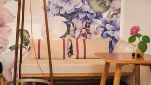 Una habitación con un sofá, una mesa de madera y una pared decorada con un mural floral.