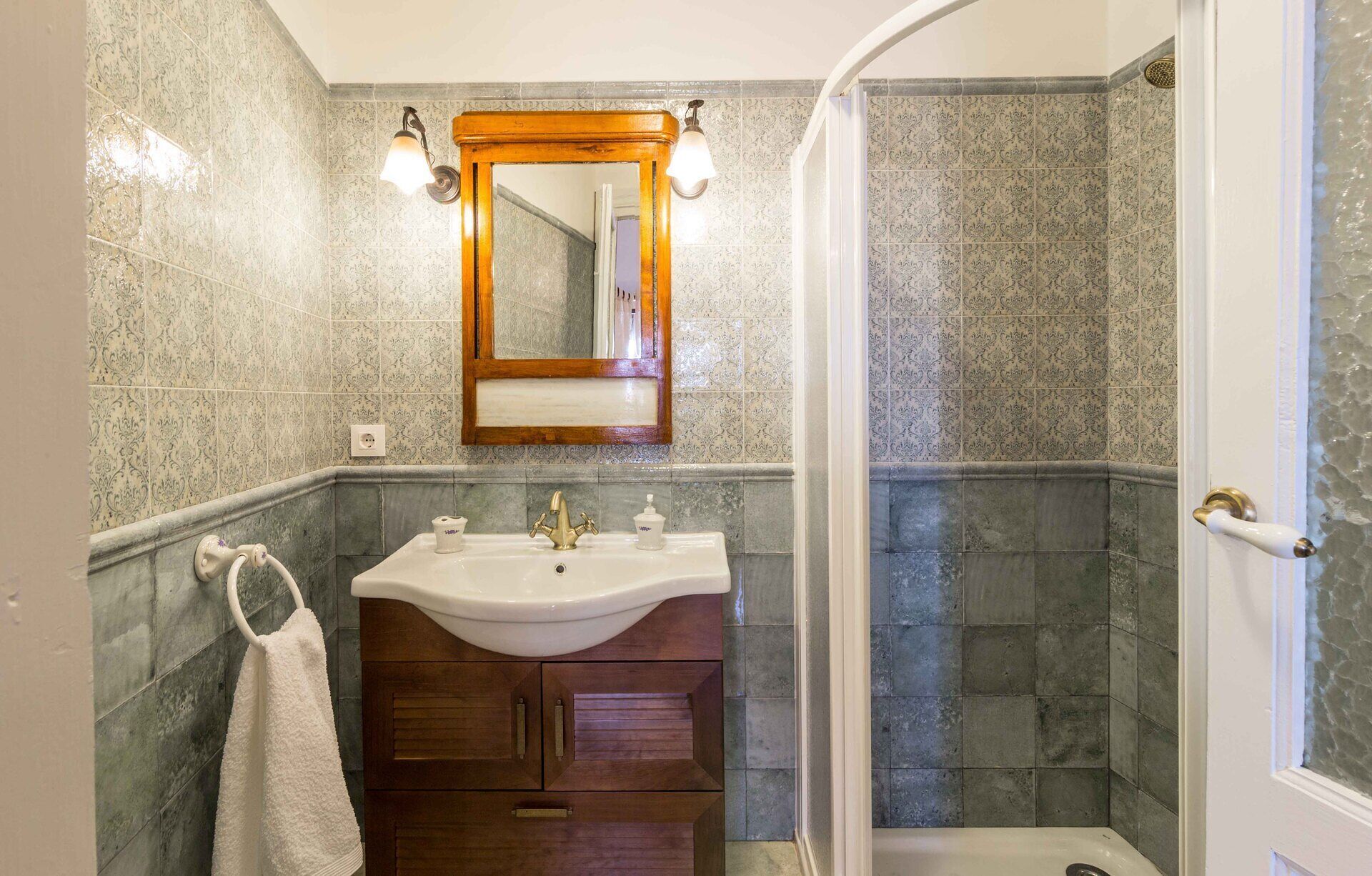 Un baño con lavamanos, espejo y ducha.