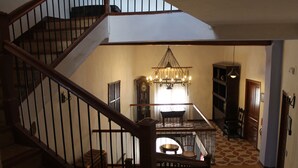 A staircase leading to a dining area with a chandelier, a clock, and a patterned floor. - Studio with Jacuzzi America (Munébrega)