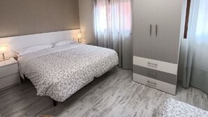 A bedroom with a bed, a wardrobe, a TV, and a window with curtains. - Double room with hydromassage bathtub 90 (Munébrega)