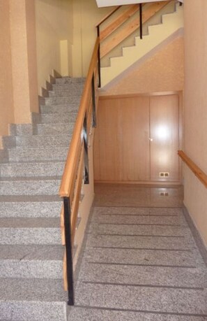 Un escalier avec des rampes en bois et une plateforme recouverte de moquette.