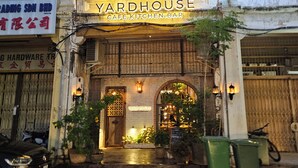A building with a sign reading "YARDHOUSE CAFE.KITCHEN.BAR" and a sign for "CONNOR'S STOUT PORTER" on the ground. - Room at Weld Quay Georgetown (George Town)