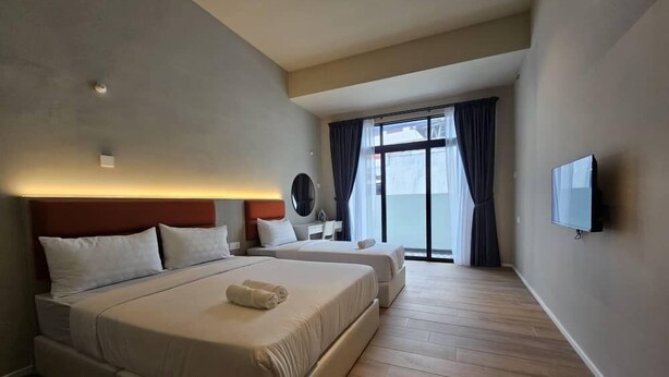A hotel room with a large bed, a TV, a bedside table, and a window with curtains. - Room at Weld Quay Georgetown (George Town)