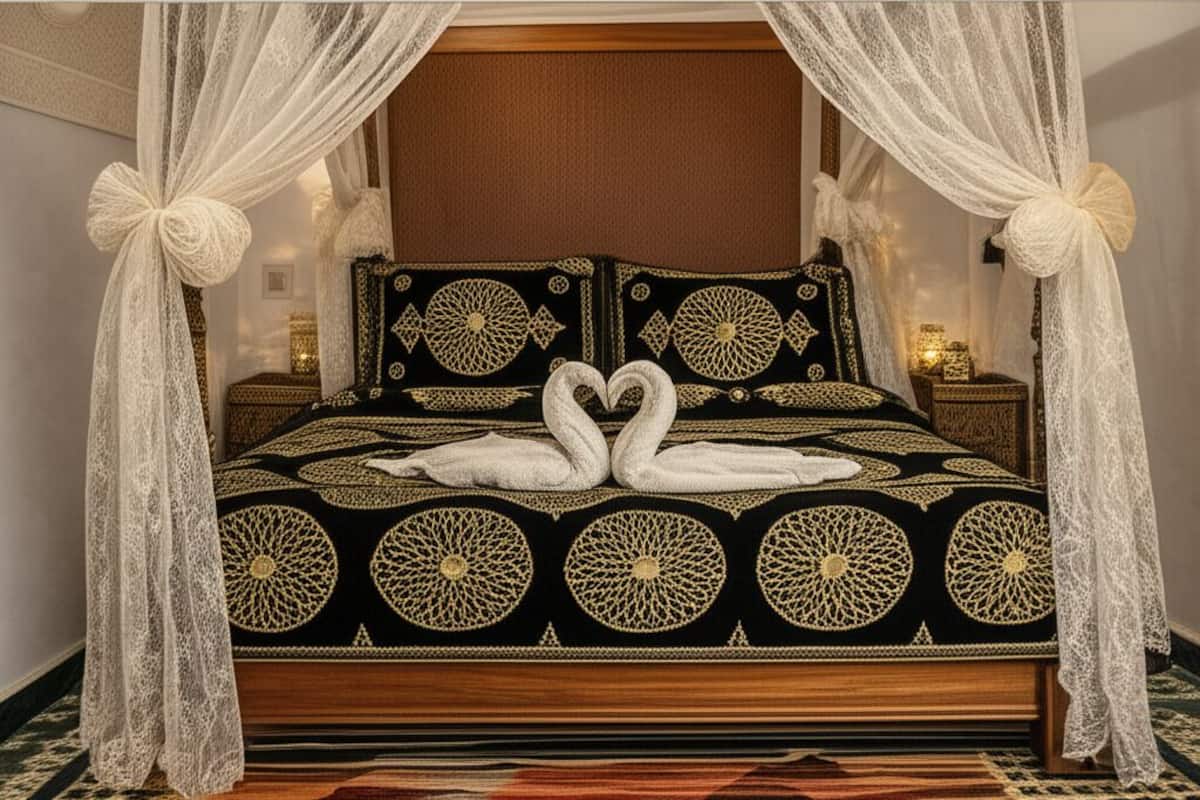 A four-poster bed with a canopy, swan-shaped pillows, and a patterned bedspread.