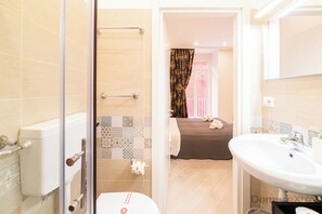 A bathroom with a shower, toilet, and sink. There is a towel rack and a glass shower door. - Dimora Sergente Maggiore By DomusExtra (Naples)
