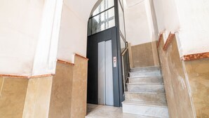 A staircase leading to a door with a glass panel, surrounded by beige and white walls. - Dimora Sergente Maggiore By DomusExtra (Naples)