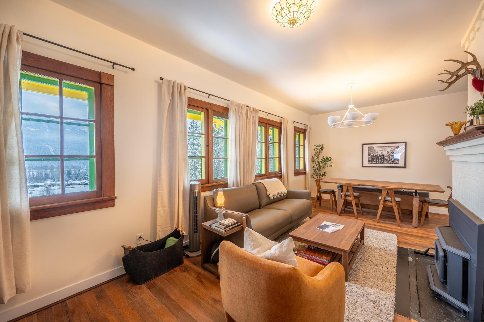 Una sala de estar acogedora con un sofá, una mesa de centro, una chimenea y un comedor con mesa y sillas.