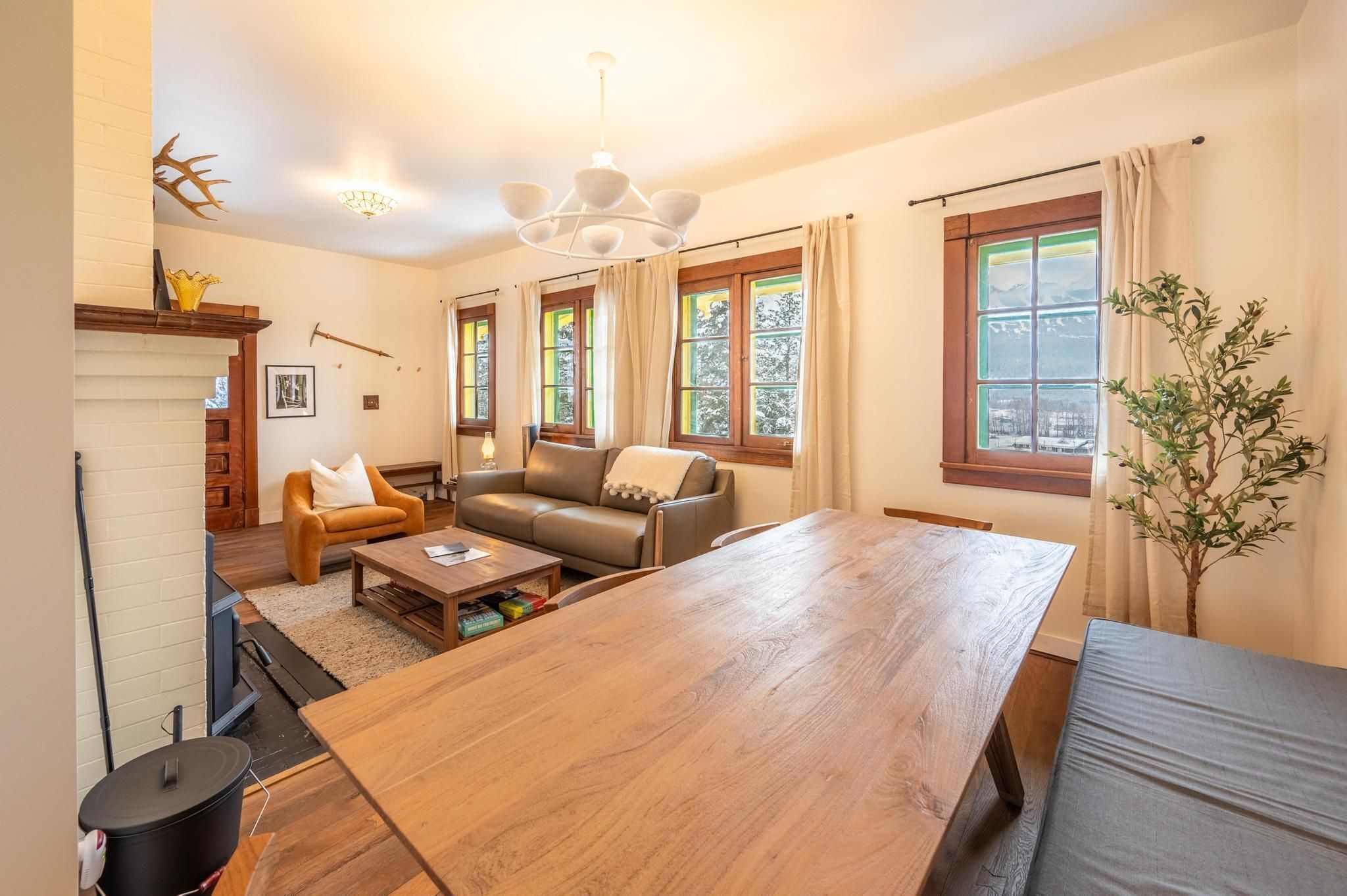 A cozy living room with a wooden dining table, a sofa, and a fireplace.