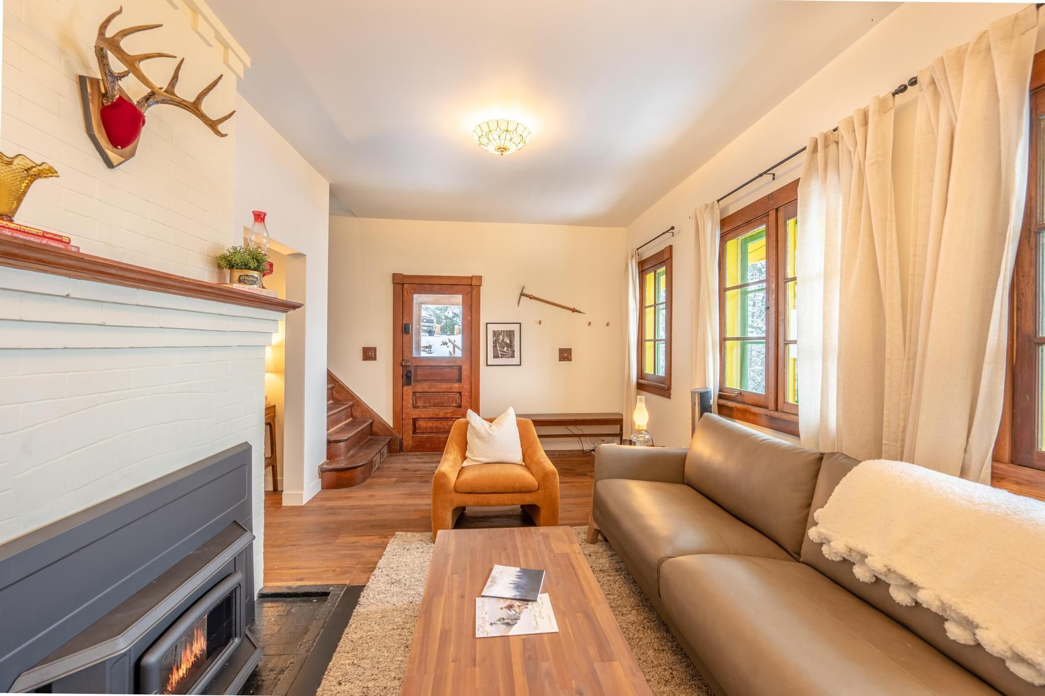 Un salon chaleureux avec une cheminée, un canapé en cuir et une table basse en bois.